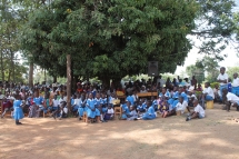 Eltern und SchülerInnen auf dem Schulgelände. Unter diesem Baum wurde unterrichtet, bevor Nashon Omondi die ersten Schulgebäude bauen lies.